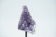A cluster of purple amethyst crystals on a stand.